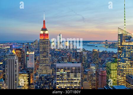 Vue sur Manhattan au coucher du soleil avec l'Empire State Building en évidence et la ligne d'horizon de New York visible en arrière-plan. Banque D'Images
