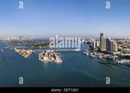 Vue aérienne du chenal Government Cut qui traverse les eaux turquoises, avec South pointe Park et les gratte-ciel de Miami Beach scintillant dans le d Banque D'Images