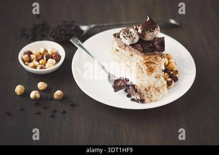 Collage dessert présentant une tranche de gâteau avec chocolat et noix sur une assiette et un bol de noix Banque D'Images