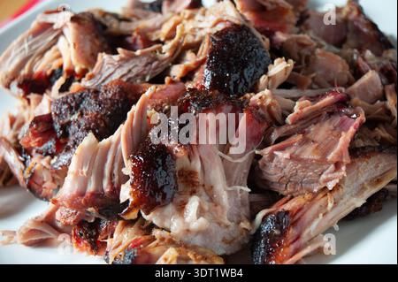 Une image en gros plan présentant du porc effiloché tendre et juteux avec une écorce fumée parfaite, mettant en évidence la texture et les saveurs succulentes de la viande fumée, Banque D'Images