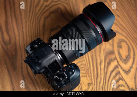 Lviv, Ukraine - 20 février 2026 : appareil photo professionnel sans miroir Canon EOS R5 Mark II avec objectif RF 24-70mm f/2.8L sur table en bois Banque D'Images