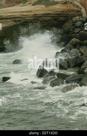 Vagues s'écrasant contre la falaise côtière rocheuse Banque D'Images
