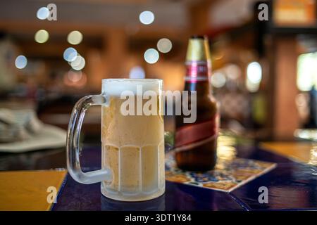 Bière légère versée dans une tasse en verre congelée avec poignée dans le restaurant Banque D'Images