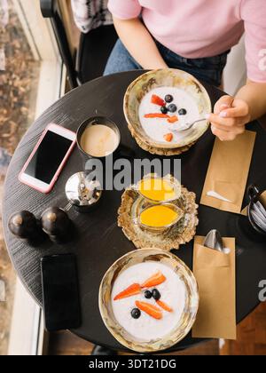 Vue de dessus de deux amis prenant le petit déjeuner avec porridge et café Banque D'Images