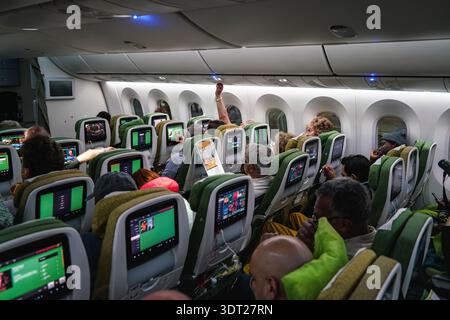 Schwechat, Autriche - 22 avril 2019 : passagers assis à leur place dans un avion commercial peu de temps avant le départ, regardant des films, verrouillage au-dessus de la tête Banque D'Images
