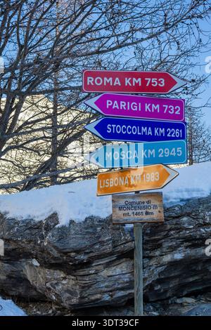 Panneau directionnel en bois coloré à Moncenisio indiquant les distances par rapport aux capitales européennes comme Rome et Paris. Piémont, Italie. Banque D'Images