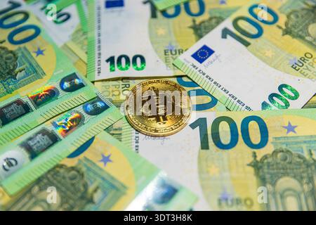 Pièce de monnaie crypto bitcoin d'or sur les billets de 100 euros Banque D'Images