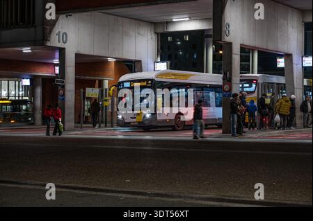Grand arrêt de bus et magasin de ligne de Lijn à la gare de Louvain photographié la nuit. Infrastructure de transport public et pôle de mobilité. Leuven, Bel Banque D'Images