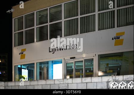 Grand arrêt de bus et magasin de ligne de Lijn à la gare de Louvain photographié la nuit. Infrastructure de transport public et pôle de mobilité. Leuven, Bel Banque D'Images