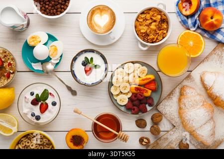 Le matin, le petit-déjeuner est composé de fruits, de yaourts et de viennoiseries sur une table en bois Banque D'Images