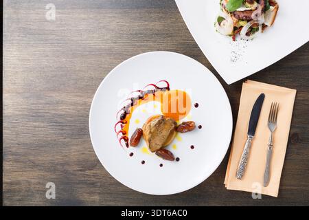 Expérience gastronomique avec deux plats plats sur une table en bois Banque D'Images