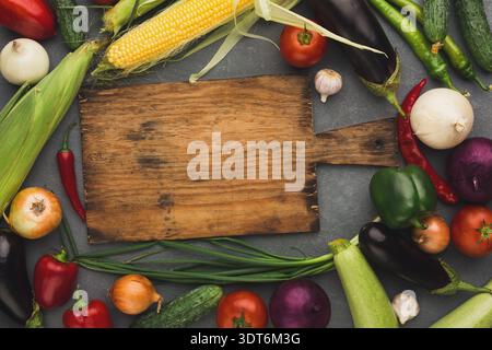 Légumes frais et planche à découper disposés dans une composition de collage créatif Banque D'Images