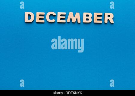 Mois de décembre affiché avec des lettres en bois sur un fond bleu avec simple Design Banque D'Images