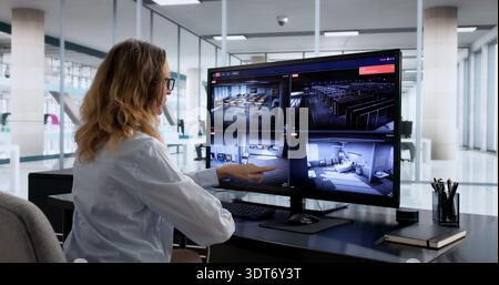 Garde de sécurité féminine utilisant le système de surveillance CCTV avancé dans la salle de contrôle Banque D'Images
