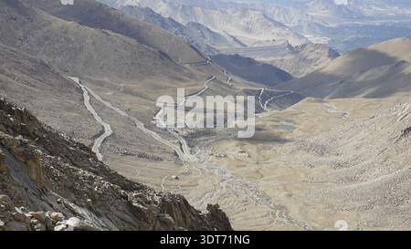 La route serpentine serpente à travers des vallées arides et des montagnes, sur le chemin de la vallée de Nubra, trekking dans le Ladakh, Himalaya, Inde Banque D'Images