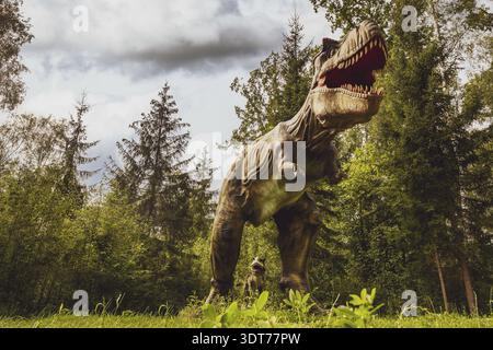 Grand modèle de dinosaure préhistorique Tyrannosaurus rex dans la nature. Paysage réaliste Banque D'Images