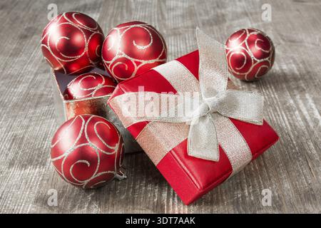 Cadeaux de Noël rouge boîte pleine de boules de noël, sur fond de bois Banque D'Images