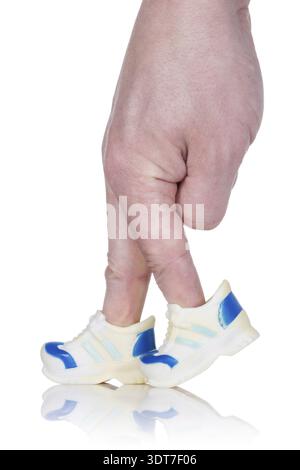 Doigts portant des entraîneurs sportifs et marche sur fond blanc Banque D'Images