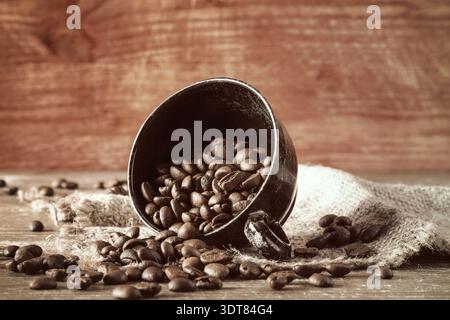 Des grains de café ont été déversés de la tasse noire Banque D'Images