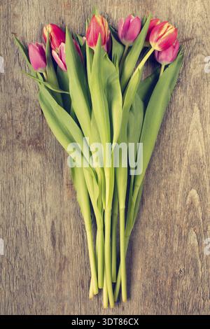 Bouquet de belles fleurs de tulipe sur fond en bois. Filtre vintage Banque D'Images