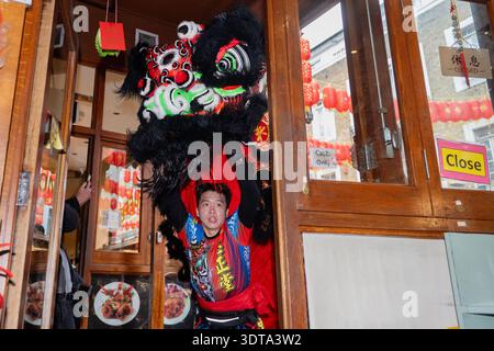 Londres, Angleterre, Royaume-Uni. 21 février 2026. Les artistes prennent part à une danse traditionnelle du lion dans Chinatown de Londres pendant les célébrations du nouvel an lunaire, où le lion mange de la laitue symbolique et des enveloppes rouges dans le rituel connu sous le nom de cai qing, représentant la collecte et la propagation de la chance, de la prospérité et des bénédictions pour l'année à venir. La performance séculaire est censée éloigner les mauvais esprits et apporter la bonne fortune aux entreprises, aux spectateurs et à la communauté au sens large. (Crédit image : © Thomas Krych/ZUMA Press Wire) USAGE ÉDITORIAL SEULEMENT ! Non destiné à UN USAGE commercial ! Banque D'Images