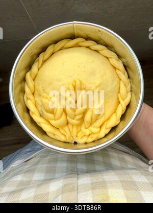 Pâte à pain sucrée tressée crue dans une poêle ronde Banque D'Images