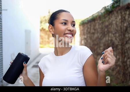 Prise de vue lumineuse en extérieur avec caméra. Image franche d'un photographe souriant à la lumière naturelle Banque D'Images