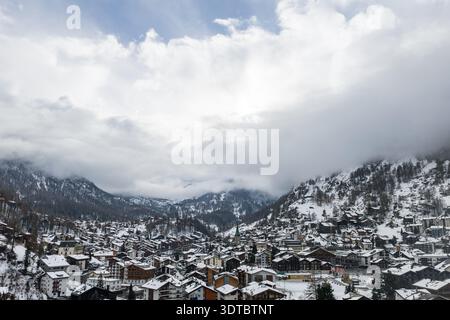 Vue panoramique aérienne de Zermatt enneigée avec flèche d'église Banque D'Images