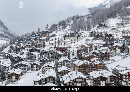 Vue aérienne de Zermatt, Suisse, chalets et gîtes dans la neige fraîche Banque D'Images