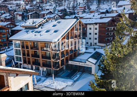 Vue aérienne de l'hôtel revêtu de bois à Zermatt enneigée, Suisse Banque D'Images