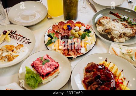 Table de restaurant festive avec plats gastronomiques, hors-d'œuvre et service de plats élégants Banque D'Images