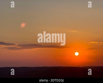 Coucher de soleil doré sur un paysage de collines sombres et vallonnées Banque D'Images