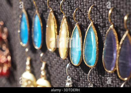 Boucles d'oreilles colorées affichées sur un marché par une journée ensoleillée Banque D'Images