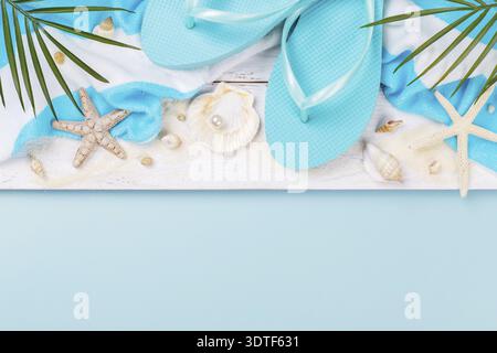 Accessoires de plage sur fond bleu, lunettes de soleil, écran solaire, tongs, serviette et chapeau, concept de vacances d'été, espace de copie Banque D'Images