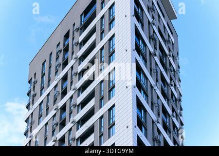 Un bâtiment résidentiel contemporain met en valeur son design épuré avec de nombreux balcons et des unités de climatisation extérieures visibles sur son wal extérieur Banque D'Images