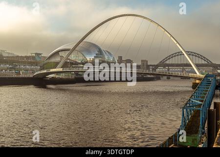 Gateshead Millennium Bridge et Sage Gateshead traversent la rivière Tyne, avec le pont Tyne visible dans la lumière du matin d'hiver. Banque D'Images