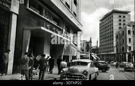 Liban des années 1950 - voiture Chevrolet devant l'hôtel le Capitole dans le centre-ville cosmopolite de Beyrouth, avec le bâtiment Lazarieh en arrière-plan - pré-guerre civile Banque D'Images
