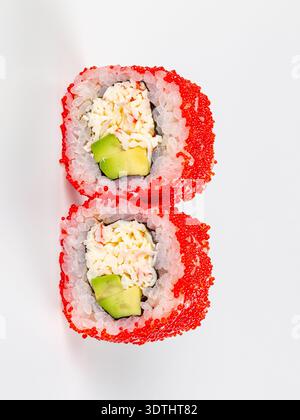 Gros plan de deux rouleaux californiens au crabe, à l'avocat et au tobiko rouge vif. Photo alimentaire minimaliste avec un éclairage lumineux sur fond blanc. Idéal f Banque D'Images