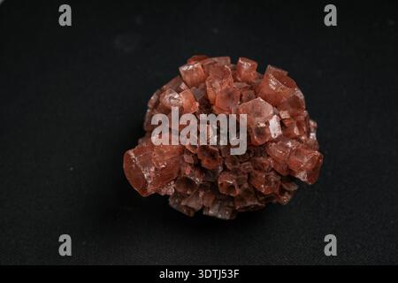 Grappe de cristaux cubiques brun rougeâtre sur fond noir, spécimen minéral photographié de haut en bas Banque D'Images