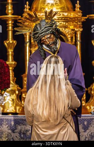 Une jeune femme vénère l'image de Gran Poder Christ lors d'une cérémonie besamanos (baiser de la main) à Séville, Andalousie, quelques jours avant Good Frida Banque D'Images