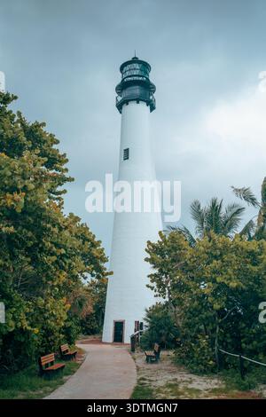 Cape Florida Lighthouse tour blanche debout haut contre un ciel couvert gris avec des palmiers verts dans Bill Baggs State Park, Key Largo, FL. Banque D'Images