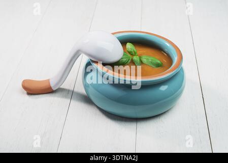 Soupe de citrouille fraîche dans un bol en céramique avec cuillère sur un vieux fond en bois Banque D'Images