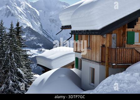 Chalets avec vue sous la neige profonde et le ciel bleu dans une station de ski Banque D'Images