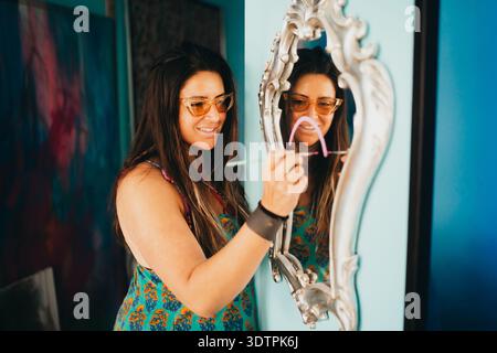 Artiste féminine en studio peignant sur miroir Banque D'Images