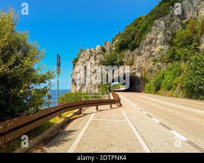 Tunnel naturel (Galleria Naturale) sur la route côtière Strada Costiera près de Trieste, Italie, falaise calcaire et vue sur la mer Adriatique Banque D'Images