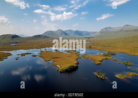 Superbe perspective de drone sur un vaste paysage écossais des hautes terres avec un lac bleu foncé parsemé de minuscules îles. Montagnes escarpées et expansives Banque D'Images