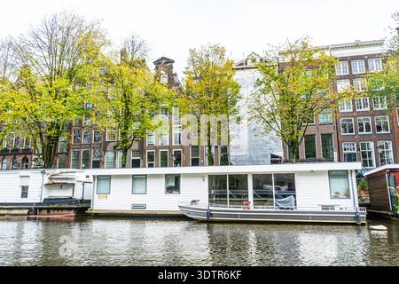 Canal d'Amsterdam avec Houseboat Maison flottante traditionnelle bâtiment. Retour en bateau sur l'eau aux pays-Bas. Paysage urbain extérieur Banque D'Images
