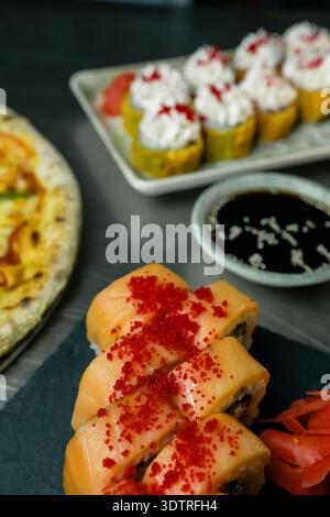 Délicieux assortiment de sushis et de cuisine japonaise avec petits pains colorés, ingrédients frais et desserts alléchants sur une table élégante Banque D'Images