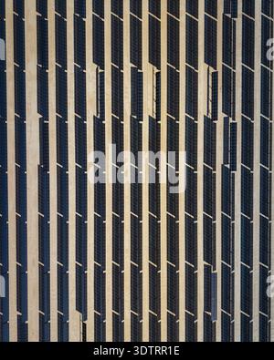 Vue aérienne de rangées soigneusement disposées de panneaux solaires projetant des ombres frappantes sur le paysage désertique, El Centro, Californie, États-Unis. Banque D'Images