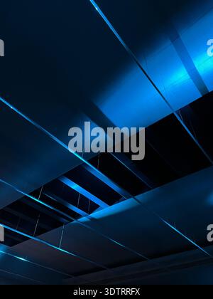 Une représentation abstraite de l'architecture moderne avec un éclairage bleu saisissant et des motifs géométriques dans un cadre contemporain Banque D'Images
